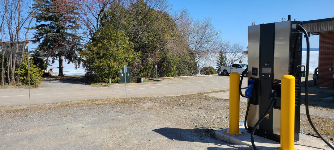 A Modern Electric Vehicle Charging Station In Haileybury Ontario Near Haileybury Beach On Lake Timiskaming With Two Charging Ports Has Both CCS Plug & CHAdeMO Plug Capable Of Accommodating Various EV Models Like Tesla With A Scenic View Of The Waterfront