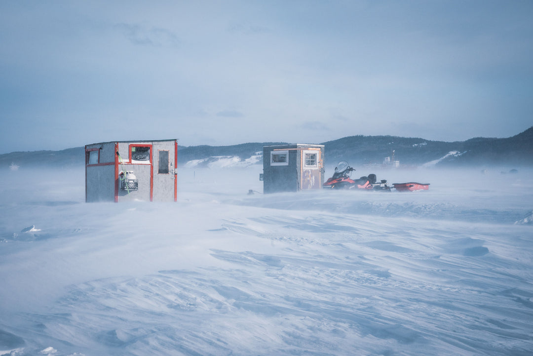 Anglers In Ice Huts Ice Fishing On Lake Timiskaming In The City Of Temiskaming Shores Ontario Surrounded By Snow-Covered Landscape Snowmobiles And A Snow Storm