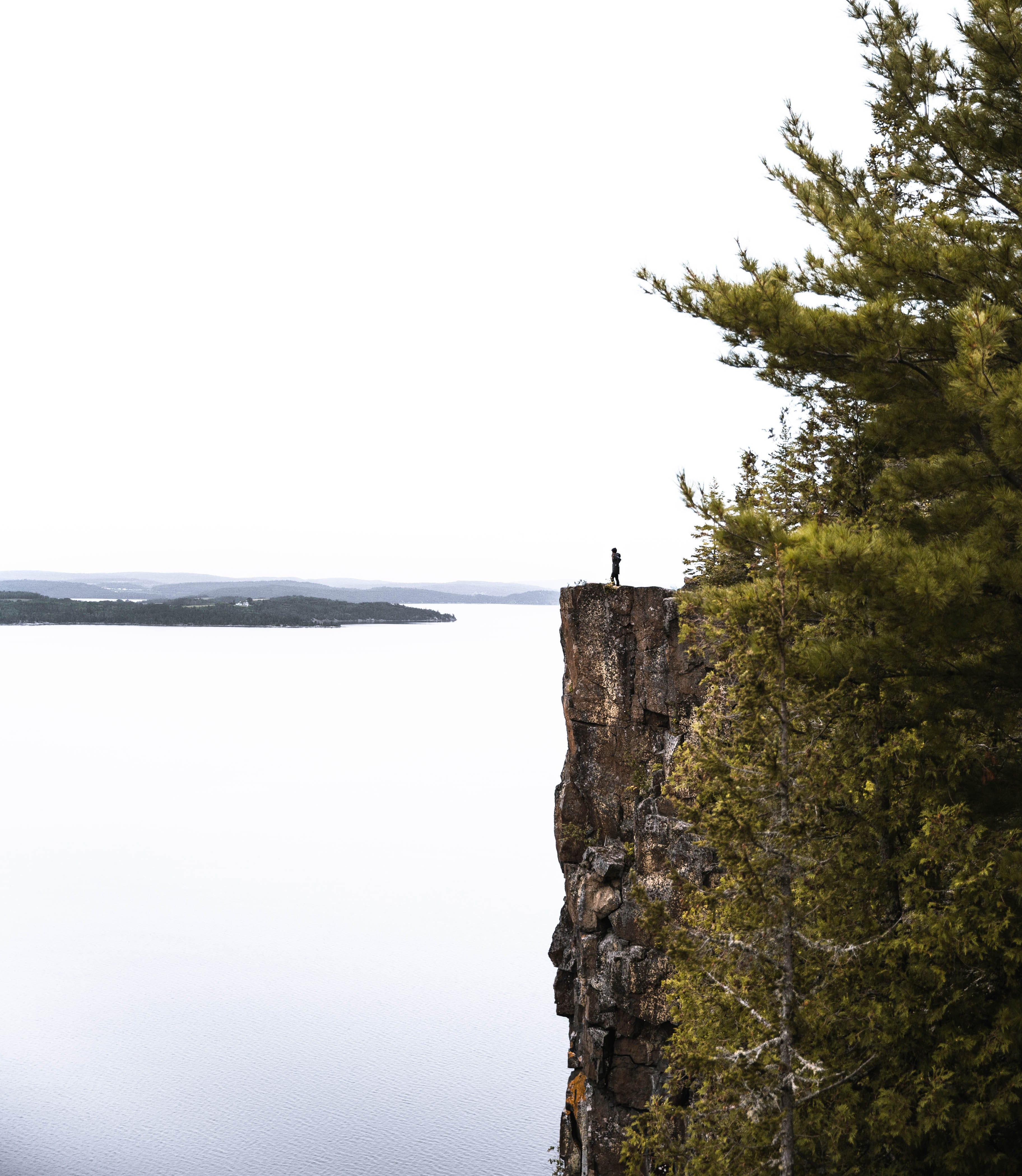 A hiker Standing Atop Devil's Rock Overlooking Lake Timiskaming Capturing The View Of The Water Surrounded By Pine Landscape Capturing The Tri-Town Essence Of Exploring The Hiking Trails In The City Of Temiskaming Shores